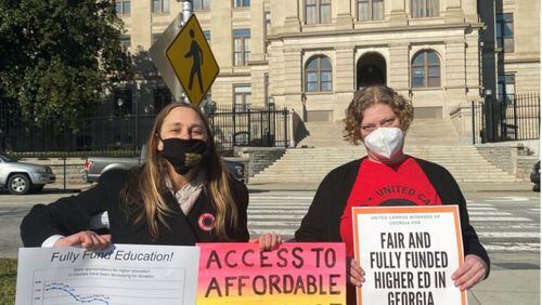 Two white women holding signs in front of the Georgia Capital in protest