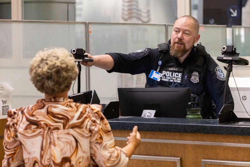 A Customs and Border Protection officer conducts a global entry interview at the U.S. Customs Passport and Control area of the Hartsfield-Jackson airport international terminal in Atlanta on Wednesday, March 27, 2024. (Arvin Temkar / arvin.temkar@ajc.com)
