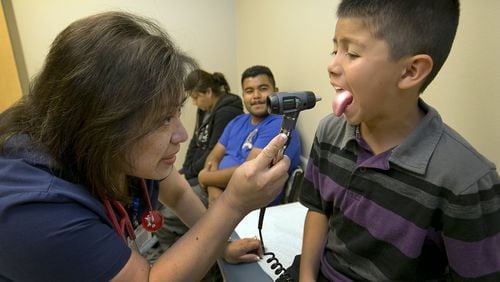 Family nurse practitioner Cathy Carrizales-Pintor examines Juan Juarez Lopez, 9, for ailments as his parents, Antonia and Jose, sit in the background of the examining room at the Dell Children’s Circle of Care Pediatrics at Lake Aire Medical Center in Georgetown. A year after the Lone Star Circle of Care was on the verge of collapse, its new leader, CEO Rhonda Mundhenk, says it’s back and adding employees and services that officials had to cut a year ago.