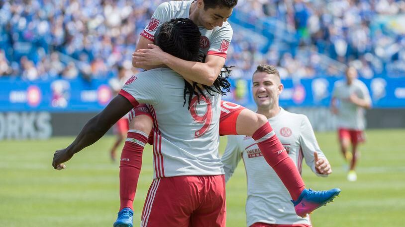 Atlanta United’s Kenwyne Jones (9) celebrates with teammates Miguel Almiron (10) and Greg Garza (4) after scoring during the first half of an MLS soccer game against the Montreal Impact, in Montreal, Saturday, April 15, 2017. (Graham Hughes/The Canadian Press via AP)