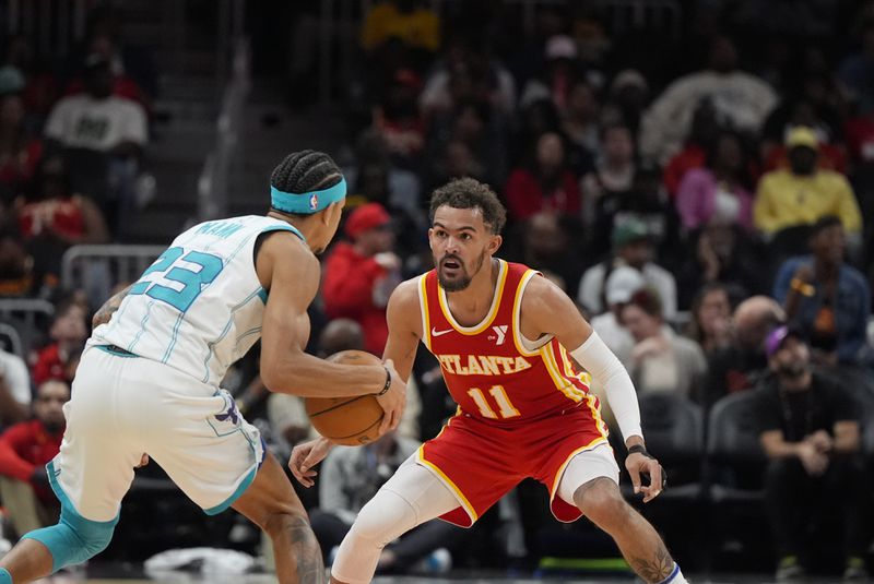 Charlotte Hornets guard Tre Mann (23) moves against Atlanta Hawks guard Trae Young (11) during the second half of an NBA basketball game, Wednesday, April 10, 2024, in Atlanta. (AP Photo/Mike Stewart)