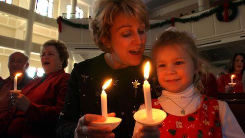 A youngster enjoys the candlelight service at Mt. Bethel United Methodist Church in Marietta. (Joey Ivansco / AJC File)