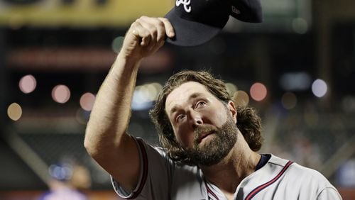 Braves starting pitcher R.A. Dickey waves his cap to fans as he leaves the game during the seventh inning. (AP Photo/Frank Franklin II)