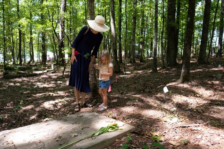 L’Anita Heiss and her daughter Lillian, 3, look at one of the few marked graves at the Pierce Chapel African Cemetery in Midland, outside of Columbus, on Monday, June 20, 2022. The cemetery was rediscovered in 2019 and work has since been done to clean, document and preserve it. Ben Gray for the Atlanta Journal-Constitution