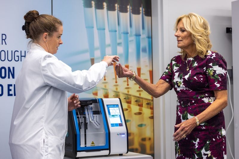 Emory lab manager Loren Sasser (left) demonstrates to First Lady Jill Biden a mixer that combines mRNA molecules and lipids into small uniform particles during a tour of a scientific research laboratory at Emory University in Atlanta on Friday, September 15, 2023. The lab, which received a $24.8 million grant with partners at Yale, the University of Georgia and elsewhere as part of President Joe Biden’s “Cancer Moonshot” program, will study possible new ways to fight cancer and other diseases, using the immune system and mRNA technology. (Arvin Temkar / arvin.temkar@ajc.com)