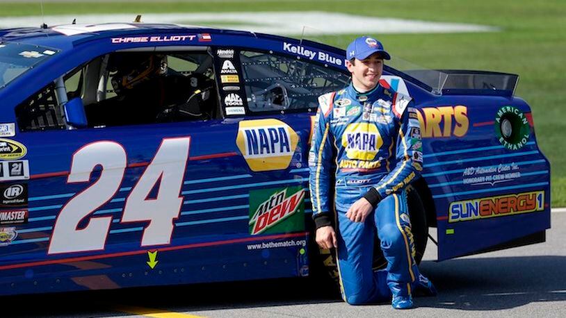 Chase Elliott kneels next to his car after he qualified for the pole position in the NASCAR Daytona 500 auto race at Daytona International Speedway, Sunday, Feb. 14, 2016, in Daytona Beach, Fla. (AP Photo/John Raoux)