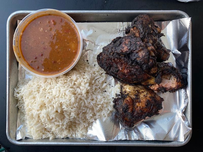 A jerk chicken plate comes with a choice of two sides. Here, the flavorful meat is paired with red beans and rice. (Ligaya Figueras / ligaya.figueras@ajc.com)