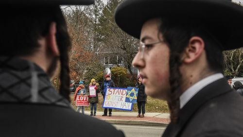 People hold signs of support near the house of a rabbi on Dec. 29, 2019 in Monsey, New York. Five people were injured in a knife attack during a Hanukkah party and a suspect, identified as Grafton E. Thomas, was later arrested in Harlem. (Stephanie Keith/Getty Images/TNS)