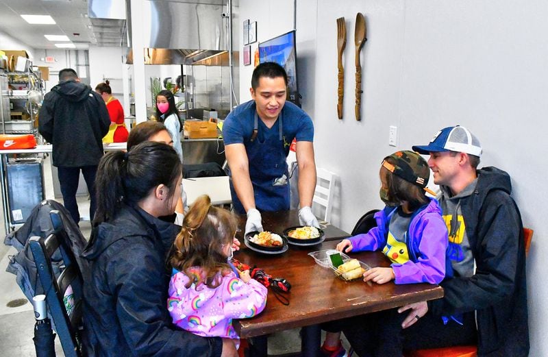 Mike Pimentel serves his cuisine to the first customers of the day at the Adobo ATL commissary. (CHRIS HUNT FOR THE ATLANTA JOURNAL-CONSTITUTION)