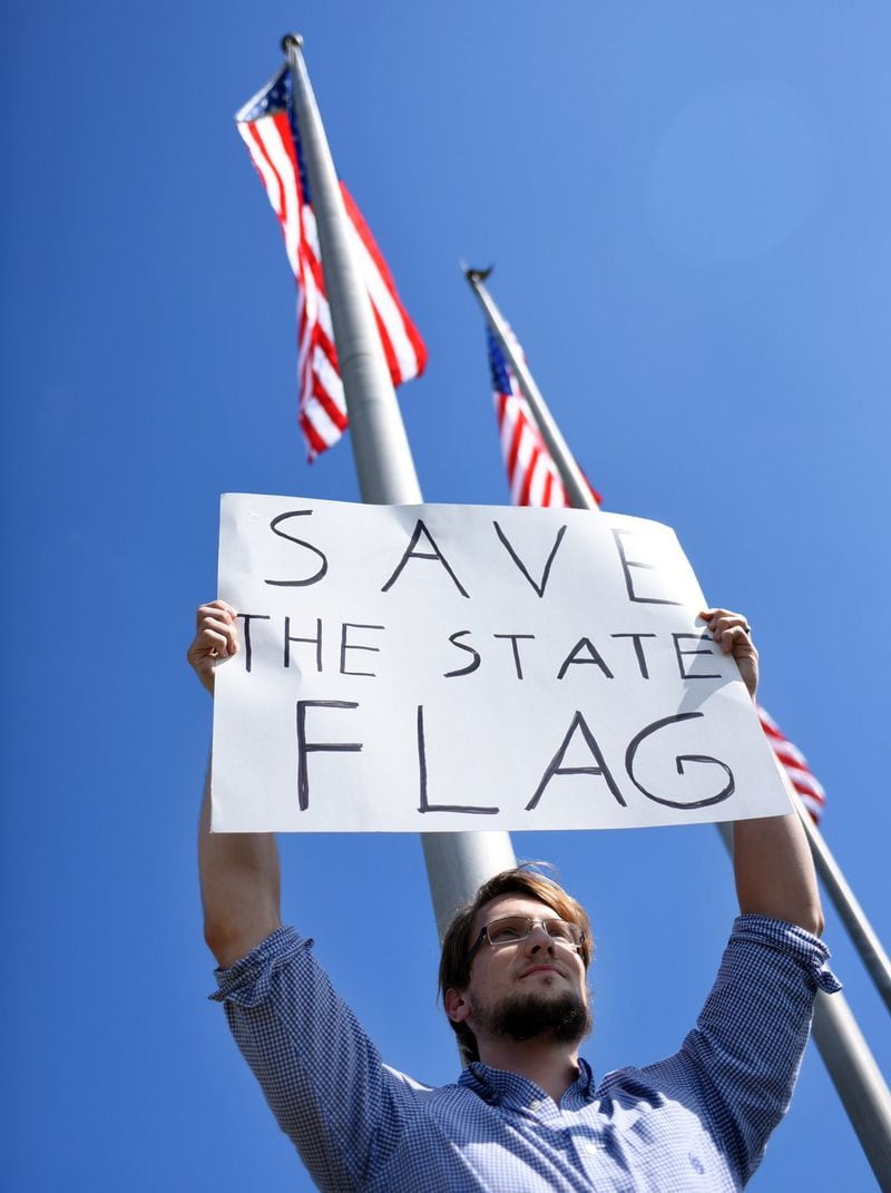 University of Southern Mississippi senior Isaac Hitt holds up a sign to protest against a group of students and faculty who want the state flag removed from campus on Wednesday, Oct. 28, 2015. The campus police removed the state flag and replaced it with the American flag. (Susan Broadbridge/The Hattiesburg American via AP)