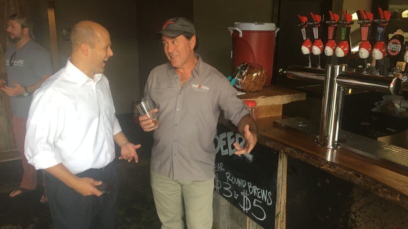 Hunter Hill, a Republican candidate for governor, shares a laugh with Red Hare Brewing Co. owner Roger Davis on the day a new alcohol law took effect.