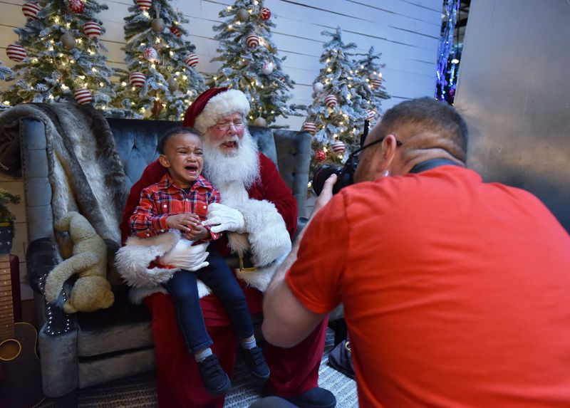 Lewis Gordon Jr., 2, is not happy about his encounter with Santa, but photographer Jeff Roffman has the knack of turning even a sad moment into a memorable one. HYOSUB SHIN / HSHIN@AJC.COM