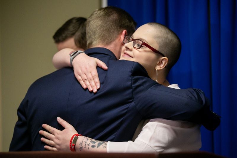 Hailie Massey, right, hugs former FBI agent Derek Somerville following a press conference at the Georgia Capitol on Thursday. Somerville, who conducted independent research into House Speaker David Ralston’s case delays last year, helped connect Massey’s family with the lawmakers pushing the amendment named for her. REBECCA WRIGHT / FOR THE AJC
