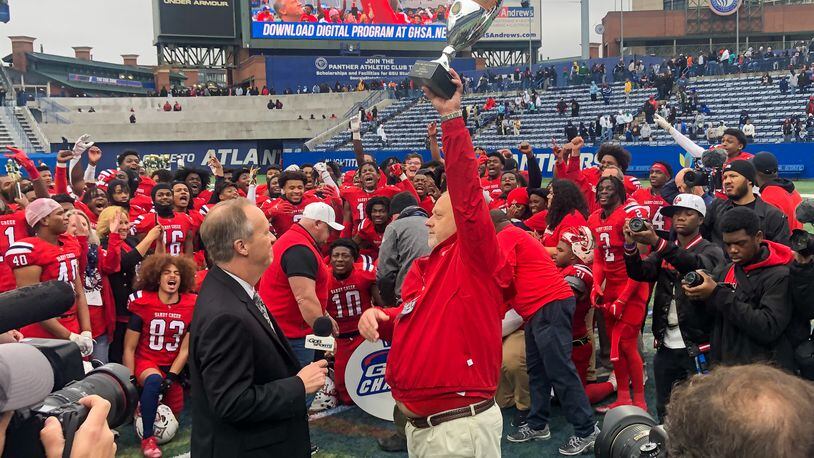 Head Coach Brett Garvin holds up the trophy after his Sandy Creek Patriots win the state football championship. (Courtesy of Fayette County Public Schools)