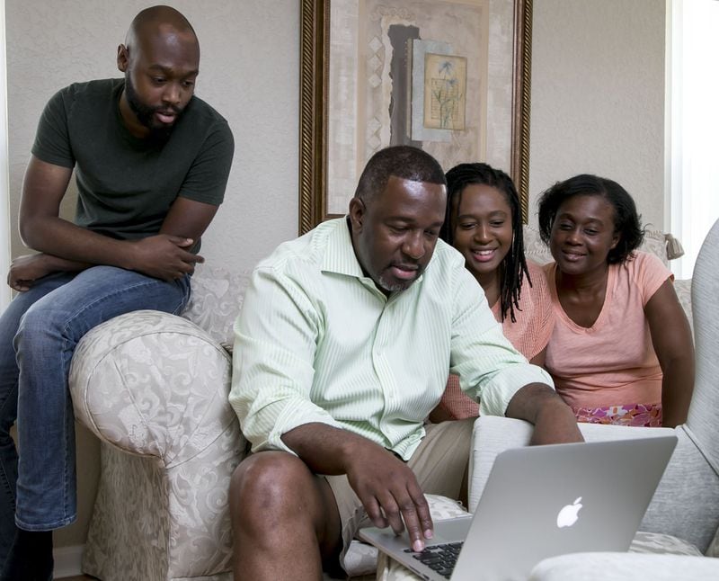 Palm Beach Post reporter Wayne Washington, his wife Shelia, and their kids Ashley and Wayne II, look at some of his Ancestry.com results at their home in Wellington on September 2, 2017. (Richard Graulich / The Palm Beach Post)