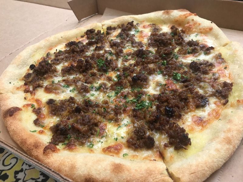 The True Story Brands group has added South African-style pizzas known as Za to its takeout menu. Pictured is the Za made with the same sweet and savory, curry-inflected flavors as a bobotie meat pie. LIGAYA FIGUERAS / LIGAYA.FIGUERAS@AJC.COM