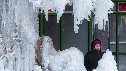AP Photo/Mark Lennihan A woman passes an ice-covered fountain in New York's Bryant Park, Friday, Jan. 5, 2018. Frigid temperatures, some that could feel as cold as minus 30 degrees, moved across the East Coast on Friday as the region attempted to clean up from a massive winter storm.