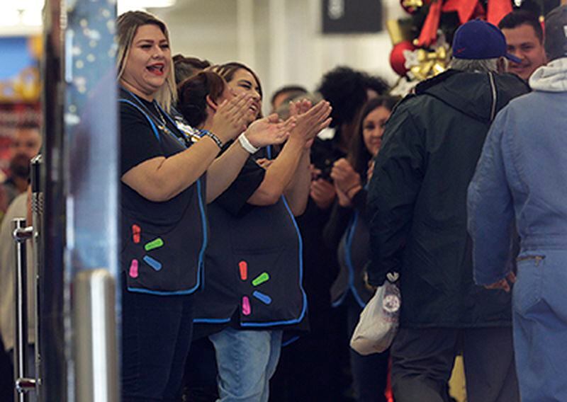 Walmart employees cheer as customers return to the store.