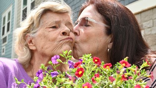 Christine Lomax Diaz and her mother, Irene Lomax, enjoy gardening together at The Phoenix at James Creek, an assisted living and memory care community, in Cumming. (Hyosub Shin / Hyosub.Shin@ajc.com)