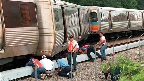 Workers examine MARTA train tracks at Piedmont Road and Miami Circle. (06/01/96)