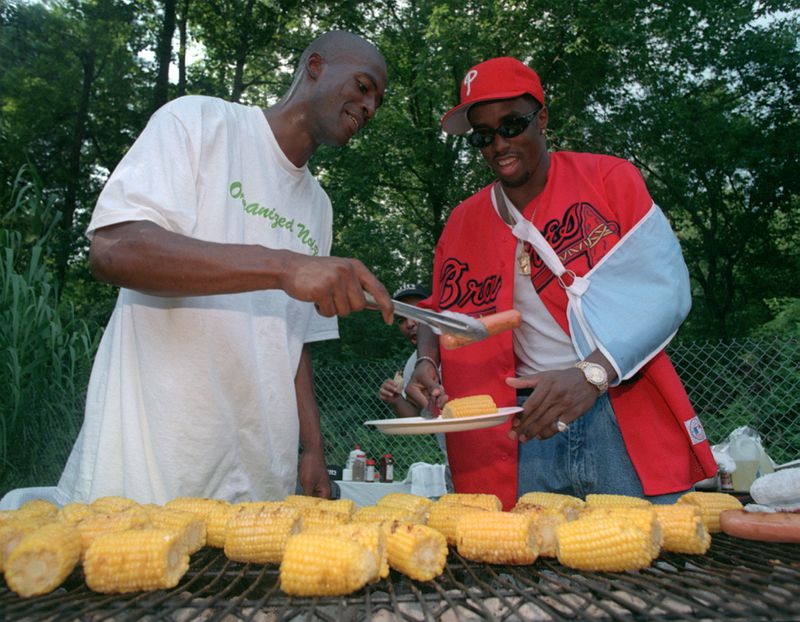 Rico Wade, left, serves up some barbeque to rap star Sean "Puffy" Combs during a party at Wade's house on Sunday, Aug. 17, 1997. (AJC Staff Photo/Mark Adams)