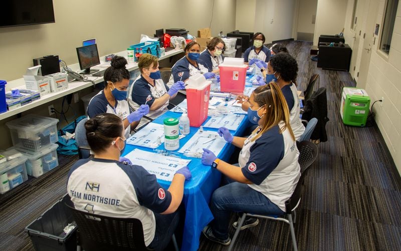 Northside Hospital pharmacists draw up vaccines into syringes during the Atlanta Braves' free vaccination clinic at Truist Park on May 1.  (Photo: Steve Schaefer for The Atlanta Journal-Constitution)