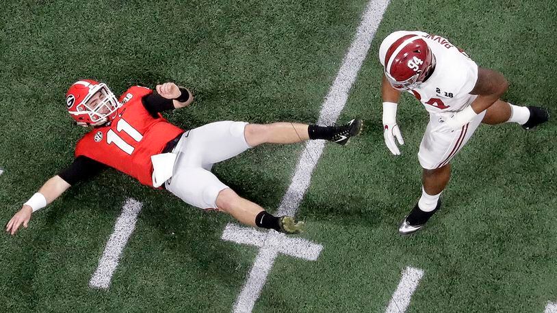 Georgia quarterback Jake Fromm is knocked down by Alabama's Da'Ron Payne during the first half of the NCAA college football playoff championship game Monday, Jan. 8, 2018, in Atlanta. The pass was intercepted. (AP Photo/John Bazemore)
