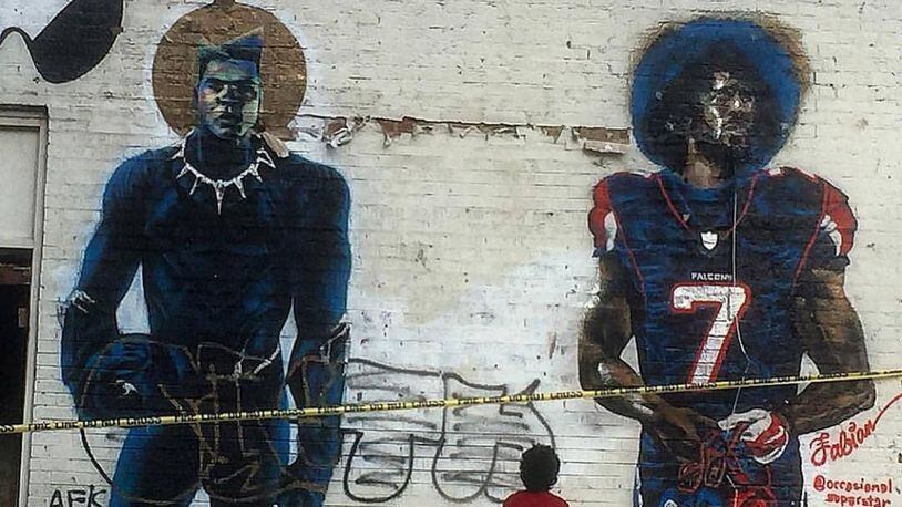 An Atlanta child admires the mural of Colin Kaepernick and Muhammad Ali, when it was on the side of a building on Fair Street and Joseph E. Lowery Boulevard.