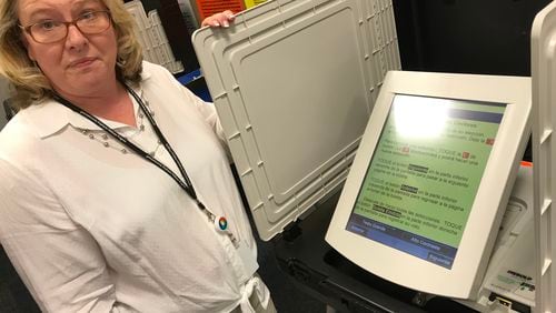 Gwinnett elections director Lynn Ledford shows off a voting machine's Spanish-language ballot. TYLER ESTEP / TYLER.ESTEP@AJC.COM