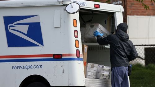 A U.S. Postal Service worker wears gloves while he stops at a collection box in Northeast Philadelphia in April. (Tim Tai/Philadelphia Inquirer/TNS)