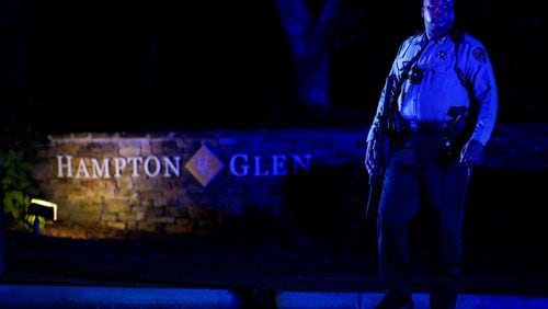 A Cobb County deputy walked around armed in front of the Hampton Glen subdivision off Irwin road after two deputies were killed Thursday evening serving a warrant. (Ben Hendren for The Atlanta Journal-Constitution)