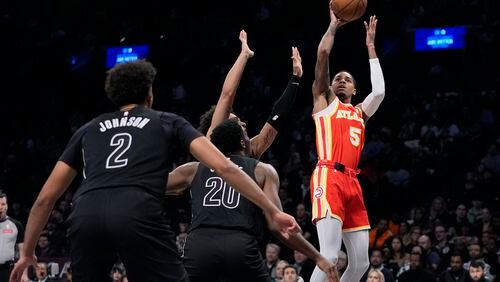 Atlanta Hawks' Dejounte Murray (5) shoots over Brooklyn Nets' Day'Ron Sharpe (20) and Cameron Johnson (2) during the first half of an NBA basketball game Thursday, Feb. 29, 2024, in New York. (AP Photo/Frank Franklin II)