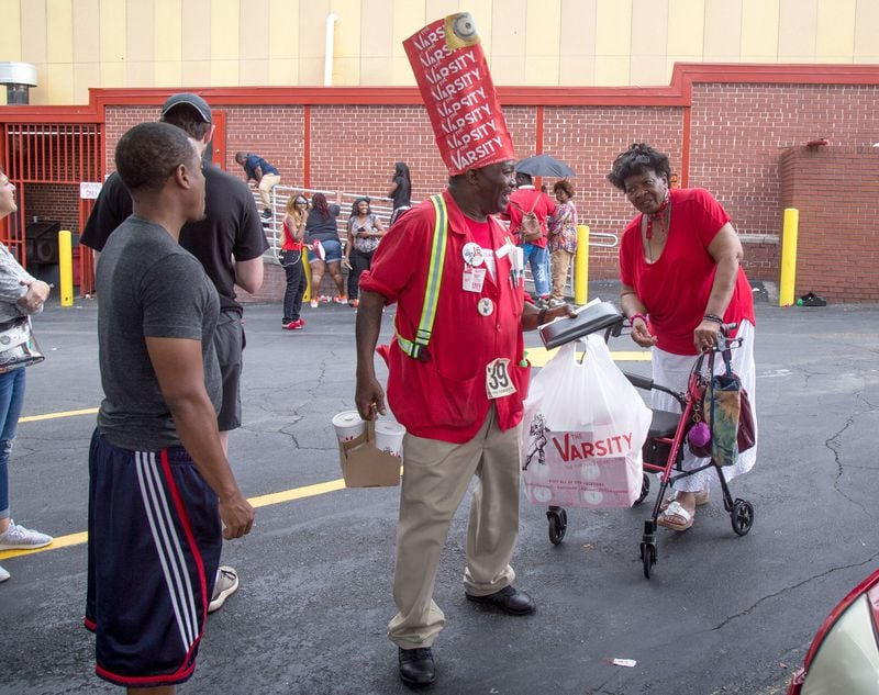 Fred Stewart, a 17-year employee, of the Varsity, delivers food during the Varsity’s 90th birthday party, Saturday, August 18, 2018. (Photo: STEVE SCHAEFER / SPECIAL TO THE AJC)