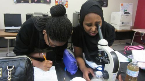 Sherifat Akinniyi (left) and Natoli Bora work in the science lab of the DeKalb Early College Academy in Stone Mountain. The school’s compressed course load allows students to enroll in college courses for their last two years of high school.