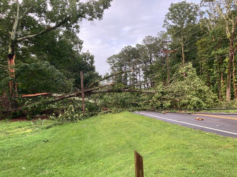 Part of a massive oak tree blocked Sugar Pike Road in Cherokee County near Big Springs United Methodist Church on Saturday, June 27, 2020. Also damaged was a utility pole, and utility wires were pulled down beneath the tree. Storms accompanied by strong winds, thunder and rain moved through the area before 5 p.m. Saturday. Hours later, the road remained blocked. (Photo: Bev O'Shea / Special to the AJC)