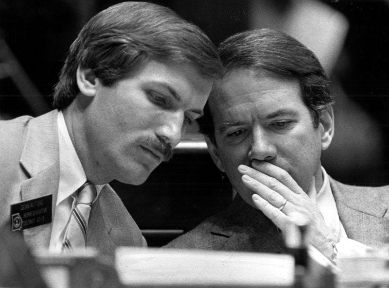 Dean Alford (left) listens to Rep. Tommy Chambless as they talk at their seats in the Georgia House of Representatives during a February 1984 meeting. Alford served five terms in the state Legislature, leaving in 1992. 