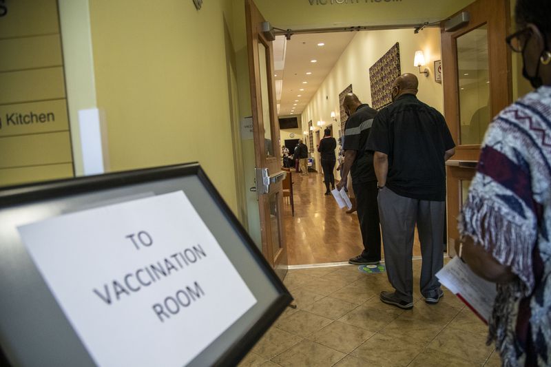 People wait to get their second COVID-19 vaccination shot at a COVID-19 vaccination event at the Lou Walker Senior Center in Stonecrest in February. (Alyssa Pointer / Alyssa.Pointer@ajc.com)
