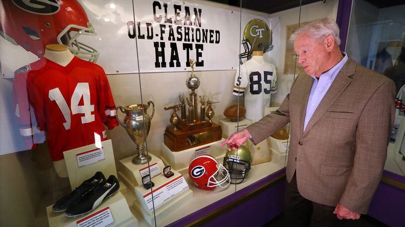 Jim McLendon, the executive director of the Georgia Sports Hall of Fame, discusses some of the items in one of the Georgia and Georgia Tech football displays. Curtis Compton/ccompton@ajc.com