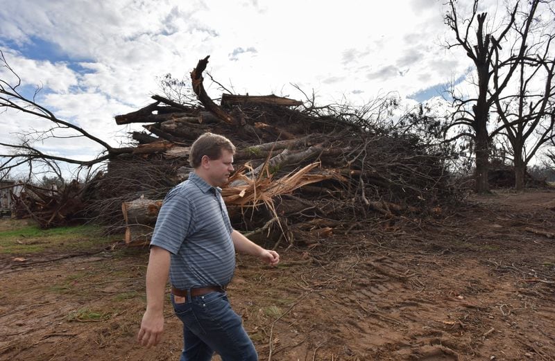 Pecan farmer Trey Pippin walks past a pile of pecan trees broken and uprooted by Hurricane Michael at his farm near Albany. Pippin and other south Georgia farmers are struggling with the results of two years of bad weather, Chinese tariffs and the government shutdown. HYOSUB SHIN / HSHIN@AJC.COM