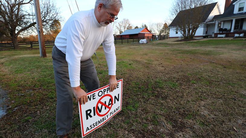 Keith Wilson said he moved from Cobb County "to get away from the Braves stadium." His 17-acre Rutledge farm now faces new growth and he posted a sign in his yard opposing the Rivian assembly plant on Tuesday, Jan. 18, 2022. “Curtis Compton / Curtis.Compton@ajc.com”`