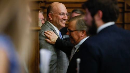 Rep. Todd Jones, R-Cumming, smiles as House members congratulate himafter they voted 163-3 in support of House Bill 520, the mental health bill he co-sponsored. (Natrice Miller/ Natrice.miller@ajc.com)
