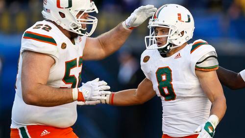 Miami wide receiver Braxton Berrios (8) and ineman KC McDermott (52) share in some of the good times this season. (AP Photo/Keith Srakocic)