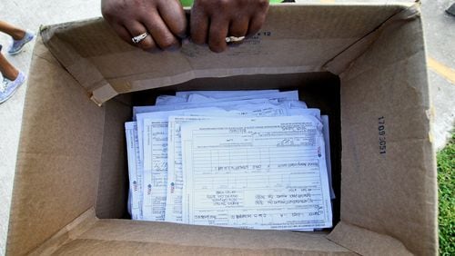 The photo shows a box of applications for housing vouchers in 2020. John Spink jspink@ajc.com