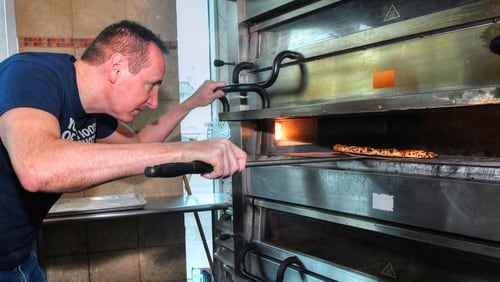 220417 Atlanta, Ga: Jeff Varasano keeps a careful eye on a margherita pizza being cooked in the oven. Thsis pizza took only a couple of minutes to cook in the 750 degree oven. Photos taken at Varasano’s, 2171 Peachtree Road NE, Atlanta, Ga. 30309. Photo for the Spring Dining Guide 2022. Photo taken Sunday April 17, 2022. Slug 051522DGiconicpizzarias. (CHRIS HUNT FOR THE ATLANTA JOURNAL-CONSTITUTION)