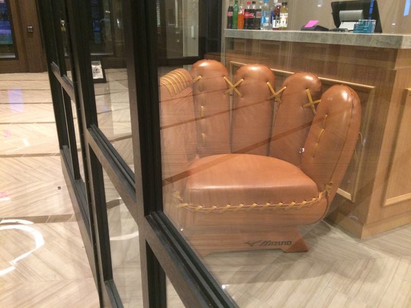 This baseball mitt chair is a tempting place to sit inside the South End Trading Company retail space at the new Omni Hotel at the Battery Atlanta. Want one of your own? It costs $6,000. Jill Vejnoska/AJC
