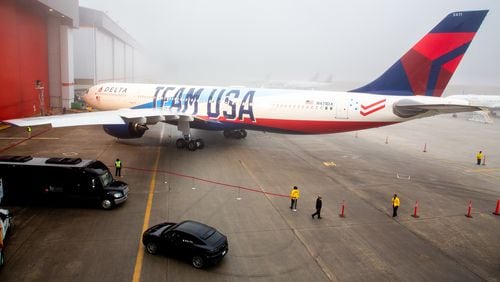 Delta employees prepare the area around Delta's new Team USA plane. Delta will be an Olympic sponsor and Team USA's official airline.  STEVE SCHAEFER FOR THE ATLANTA JOURNAL-CONSTITUTION