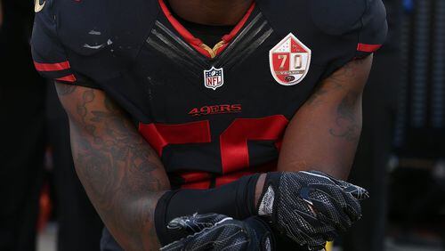 Many athletes are following quarterback Colin Kaepernick’s example and taking a knee during the national anthem to protest police brutality, including his San Francisco 49ers teammate Eli Harold. (Daniel Gluskoter/AP Images)