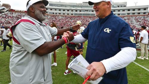 Florida State associate head coach/defensive tackles coach Odell Haggins, left, shakes hands with Georgia Tech quarterbacks coach Chris Weinke after of an NCAA college football game Saturday, Oct. 29, 2022, in Tallahassee, Fla. Weinke was the Heisman Trophy-winning quarterback for Florida State in 2000. Florida State won 41-16. (AP Photo/Phil Sears)
