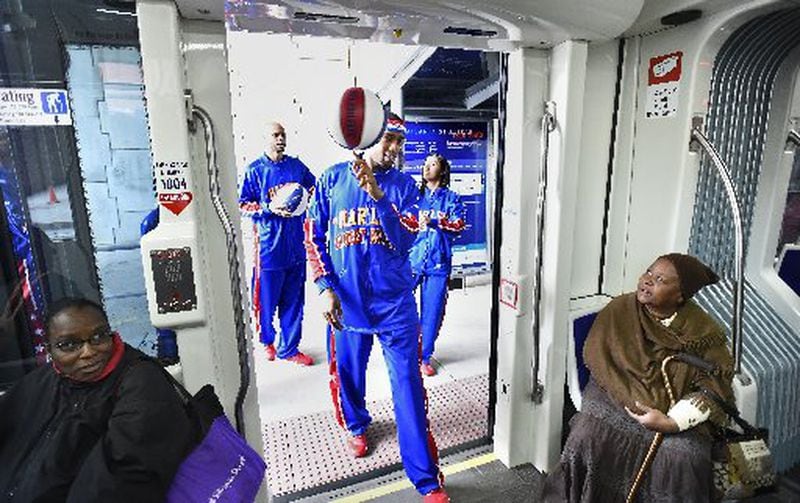 Harlem Globetrotters' Brawley "Cheese" Chisholm leads teammates Jonathan "Hawk" Thomas, left, and Tammy "T-Time" Brawner aboard the new Atlanta Streetcar. CONTRIBUTED BY DAVID TULIS