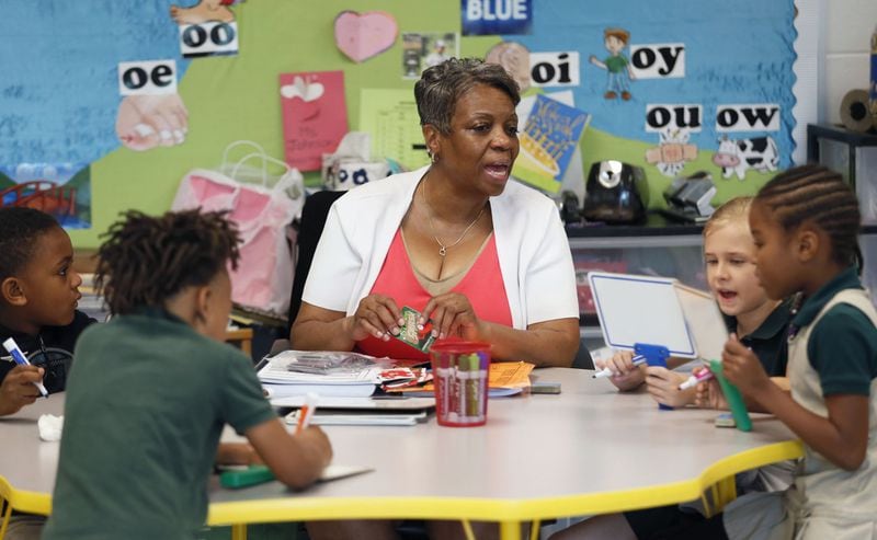 Cheryl Johnson, a teacher in the literacy center in Atlanta’s Charles R. Drew Charter School dictates words to first graders to spell out as part of a word game. 